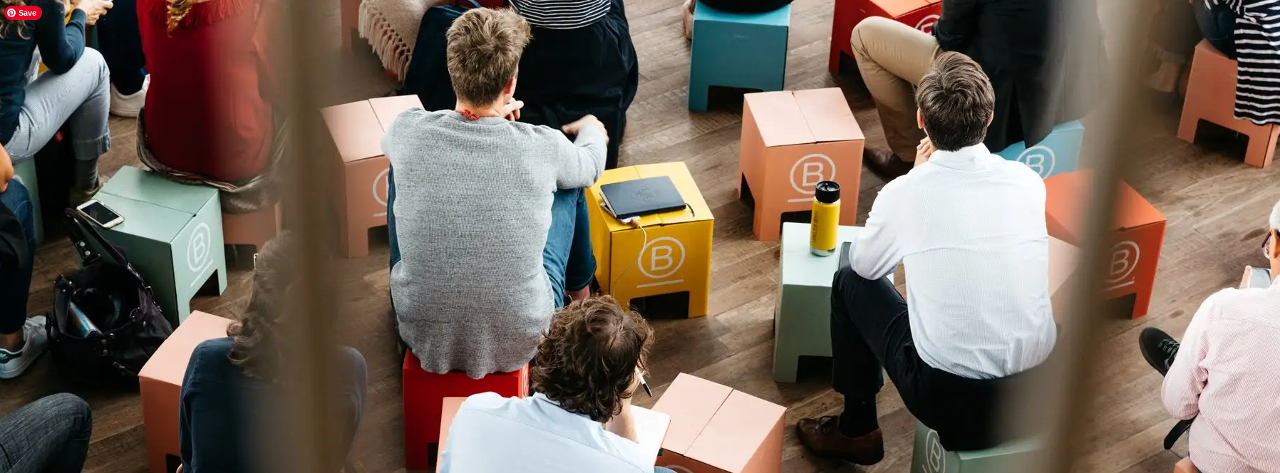 Photo showing people sitting on B Corp-branded cardboard stools.